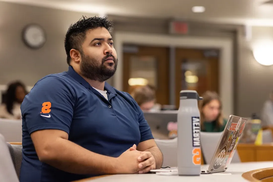 Student sitting in lecture hall with computer open in front of them,