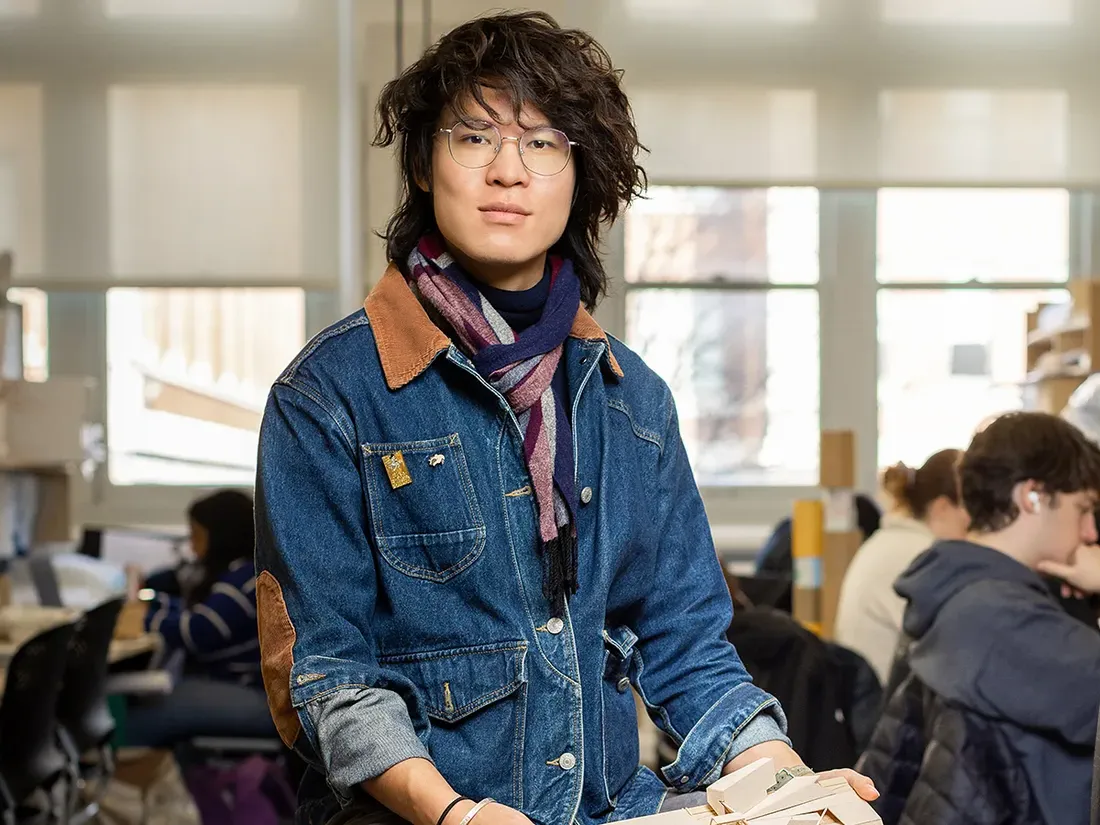 A portrait of Qianzhen Li posed with the architecture studio in the background.